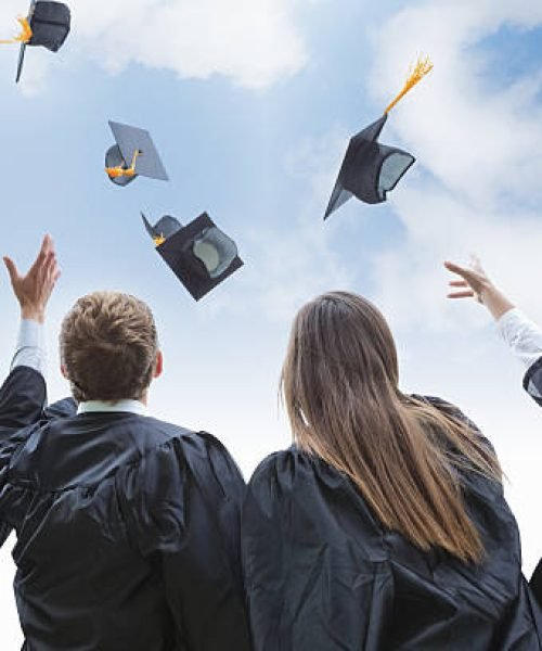 Excited group of college graduates throwing their hats in celebration